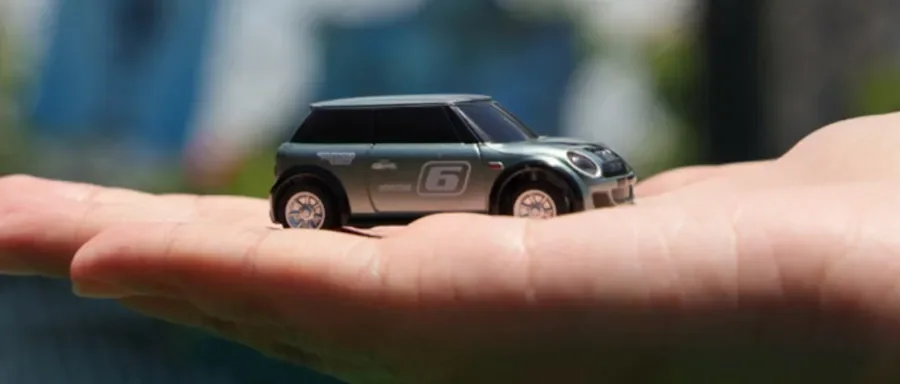 Voiture radiocommandée à l’échelle 1/76 posée dans le creux d’une main, qui montre ses 5,8 cm de long