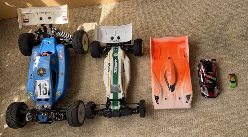 Comparaison de taille entre plusieurs voitures radiocommandées, d’un grand buggy 1/8 à une très petite voiture 1/76