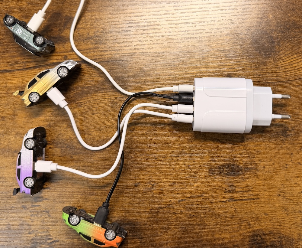 Quatre voitures RC 1/76 reliées à un chargeur USB quatre ports